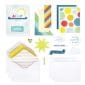 Contents of the Creative Memories Card Kit with decorated envelopes, white card bases, a decorative storage box, and embellishments and sayings in bright hues
