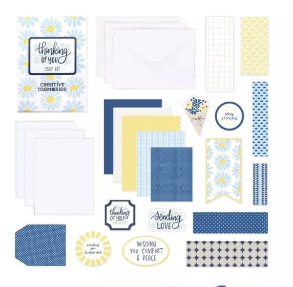 Contents of the Creative Memories Thinking of You Card Kit including card bases, envelopes, blue and yellow paper and cut outs and sayings such as My Thoughts are With You.